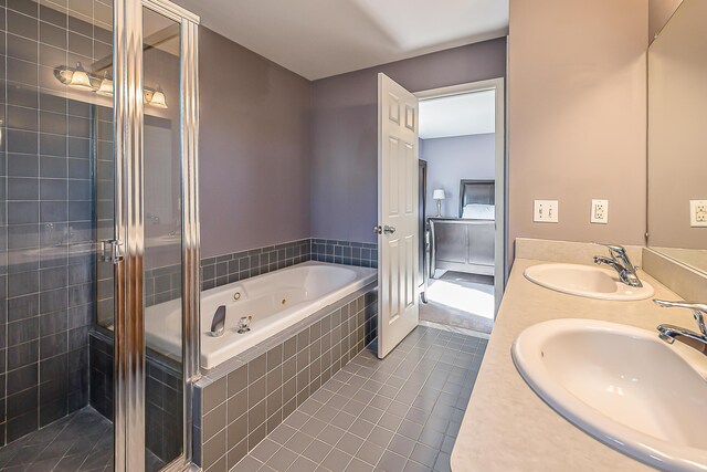 full bathroom with a jetted tub, a sink, tile patterned floors, and a stall shower