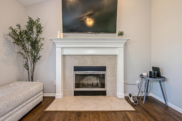 room details featuring baseboards, wood finished floors, and a fireplace