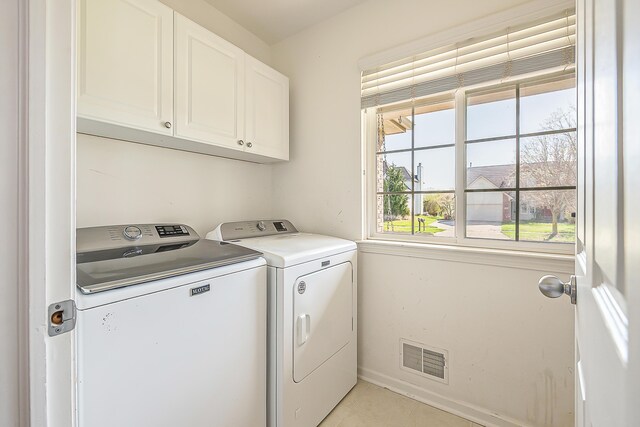 washroom with visible vents, washing machine and clothes dryer, cabinet space, light tile patterned floors, and baseboards