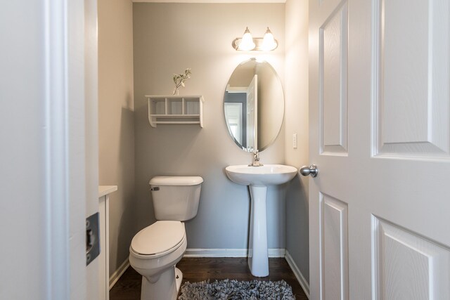 bathroom with baseboards, toilet, and wood finished floors