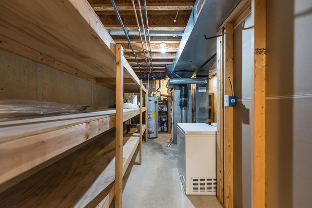unfinished basement featuring gas water heater and refrigerator