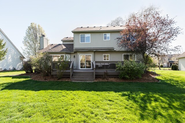 back of house with a wooden deck, a yard, and a chimney
