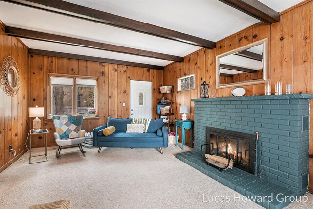 carpeted living area with beamed ceiling, a brick fireplace, and wood walls