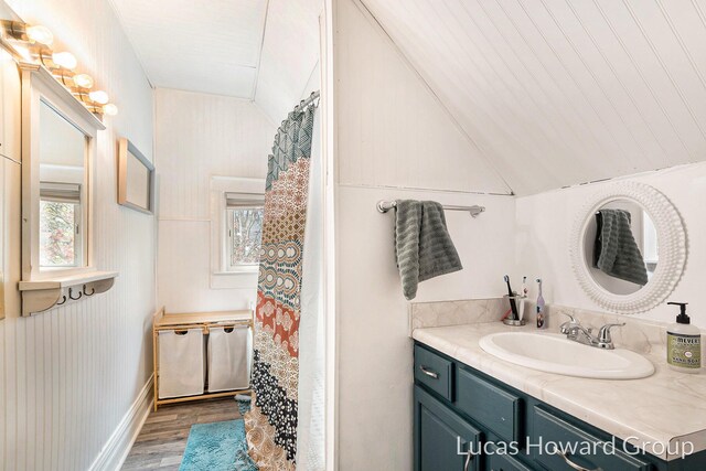 full bath featuring vanity, vaulted ceiling, and wood finished floors