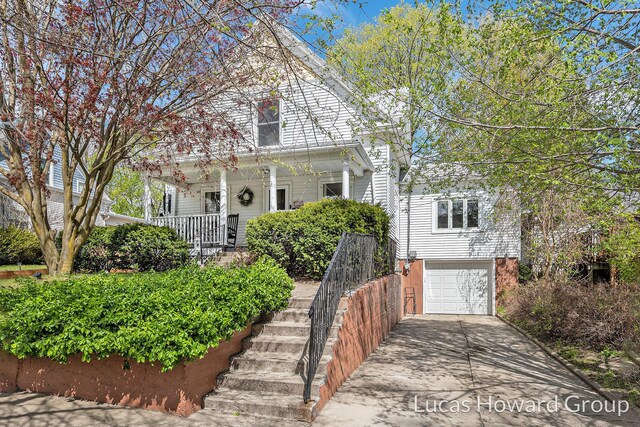 view of front of property with covered porch, stairway, driveway, and an attached garage
