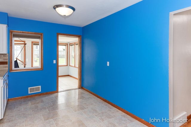 empty room with visible vents and baseboards