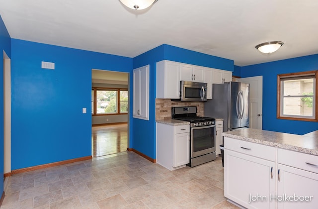 kitchen featuring white cabinets, light countertops, stainless steel appliances, baseboards, and visible vents