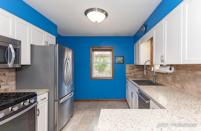 kitchen featuring a sink, white cabinetry, appliances with stainless steel finishes, and tasteful backsplash