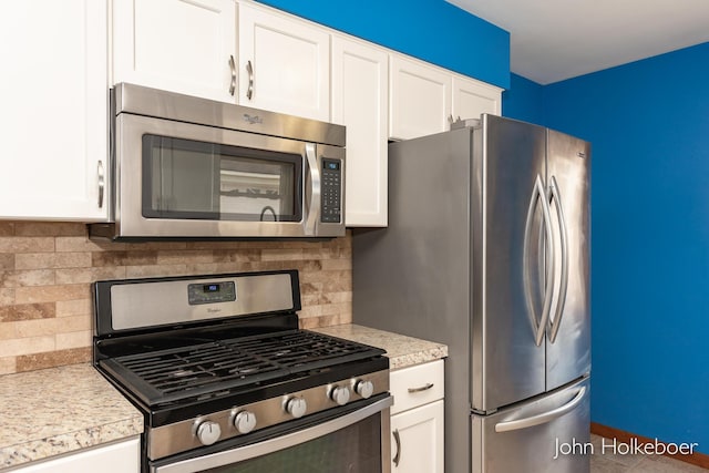 kitchen featuring light countertops, white cabinetry, appliances with stainless steel finishes, and tasteful backsplash