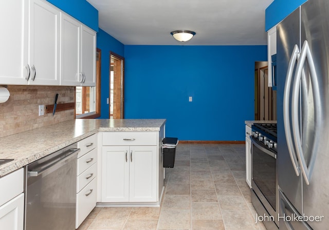 kitchen featuring appliances with stainless steel finishes, tasteful backsplash, light countertops, white cabinets, and a peninsula