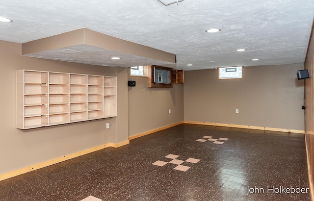 below grade area with baseboards, recessed lighting, a textured ceiling, and tile patterned floors