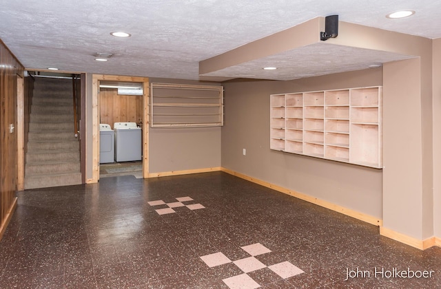 finished below grade area with independent washer and dryer, a textured ceiling, tile patterned floors, baseboards, and stairway