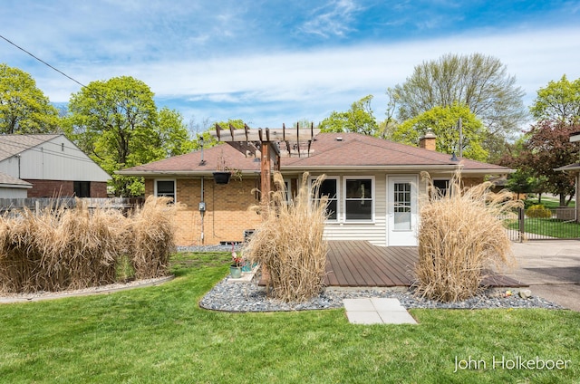 rear view of property with a lawn, fence, a chimney, and a deck