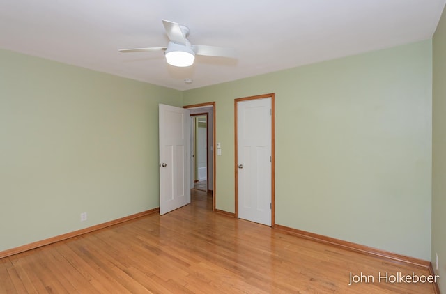 empty room with baseboards, ceiling fan, and light wood-style floors