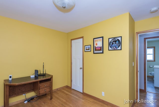 home office featuring baseboards and wood finished floors