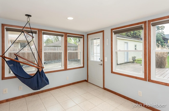 doorway featuring baseboards and a wealth of natural light