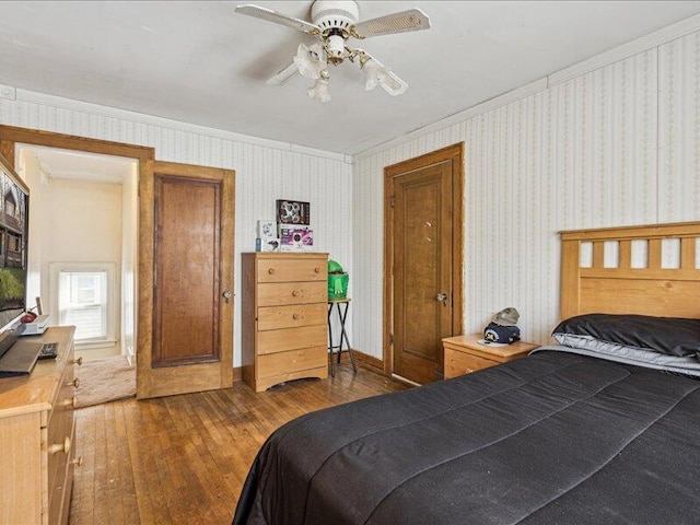 bedroom featuring crown molding, a ceiling fan, and hardwood / wood-style flooring