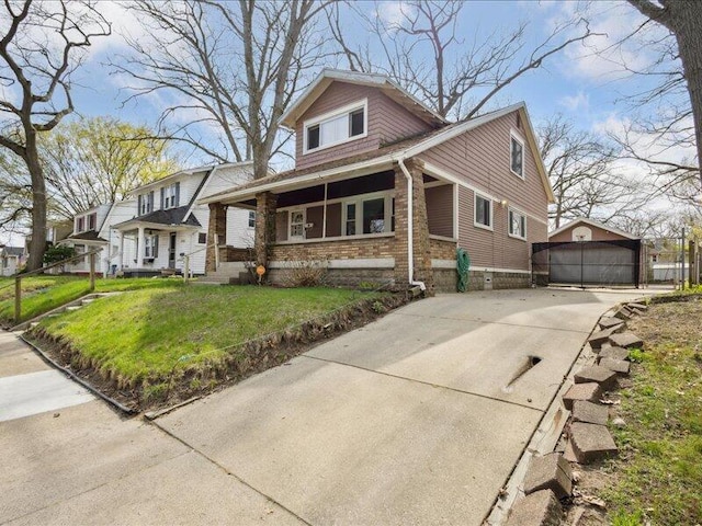 view of front of home with a garage, a front yard, an outbuilding, and stone siding