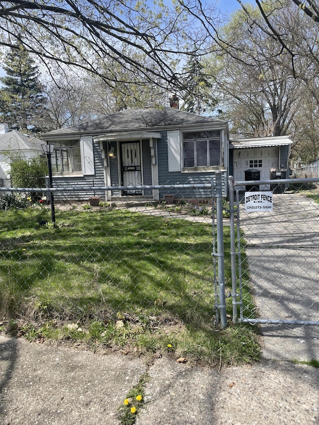 15519 Plainview Ave, Detroit, MI 48223 - view of front facade with a front lawn, a fenced front yard, a chimney, and concrete driveway