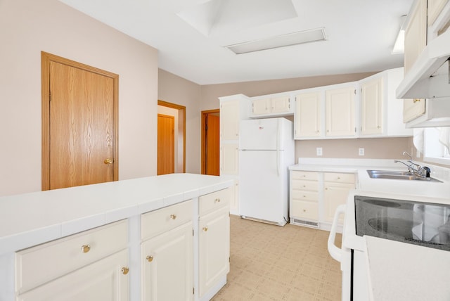 2326 Burnsline Rd, Brown City, MI 48416 - kitchen featuring freestanding refrigerator, light flooring, under cabinet range hood, range, and white cabinetry