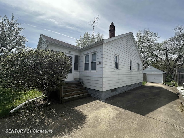 view of front of home with crawl space, a chimney, an outbuilding, a garage, and entry steps