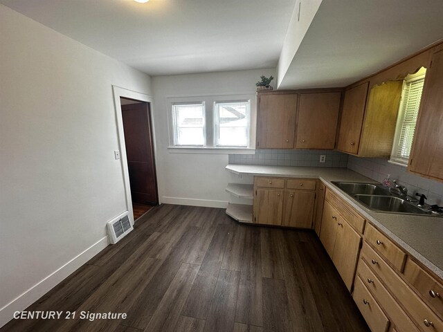 kitchen featuring visible vents, dark wood finished floors, a sink, light countertops, and baseboards