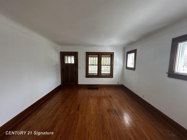 foyer entrance with baseboards, dark wood-style flooring, and visible vents