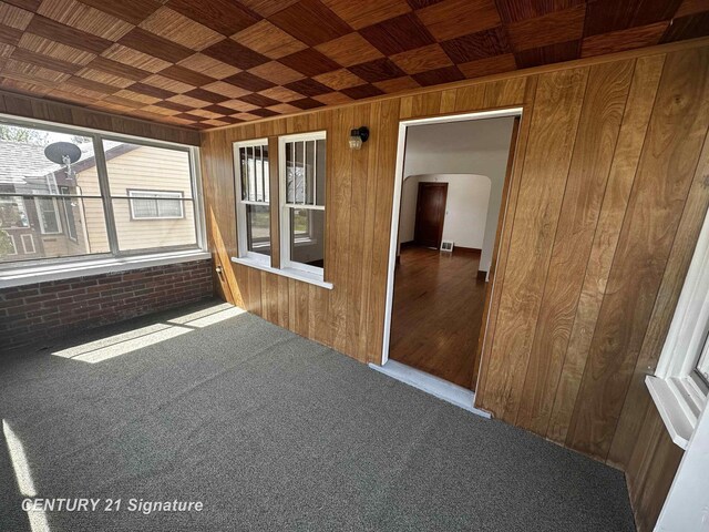 unfurnished sunroom with arched walkways