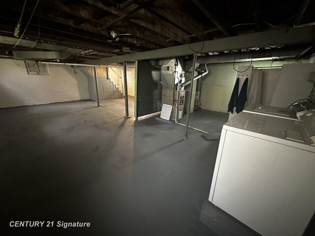 unfinished below grade area with washer and clothes dryer and heating unit