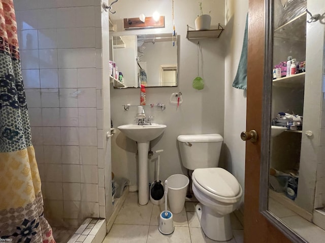 bathroom featuring tile patterned flooring, a stall shower, and toilet