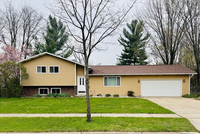 tri-level home with a garage, entry steps, driveway, and a front lawn