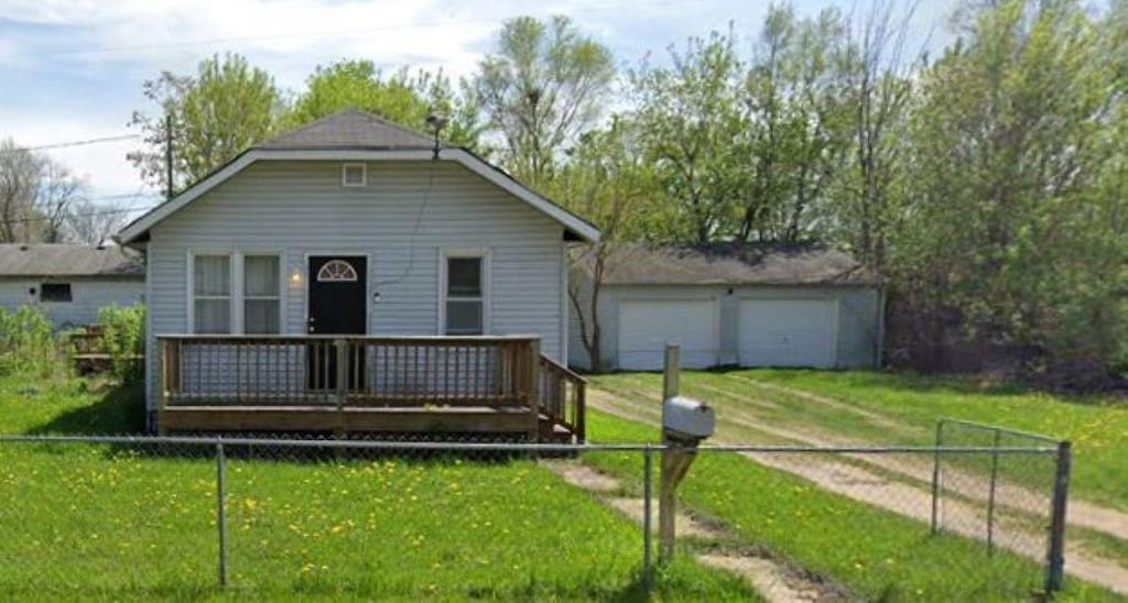3018 Dakota Ave, Flint, MI 48506 - view of front of house featuring fence, a wooden deck, driveway, and a front lawn