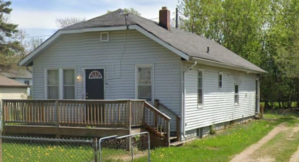 3018 Dakota Ave, Flint, MI 48506 - view of front of home with fence, a chimney, and a wooden deck
