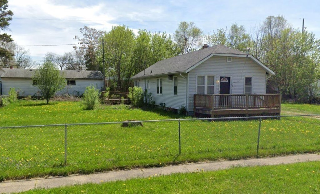 3018 Dakota Ave, Flint, MI 48506 - view of front of house with a wooden deck, a fenced backyard, and a front lawn