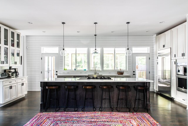 kitchen with light countertops, white cabinetry, appliances with stainless steel finishes, and a spacious island