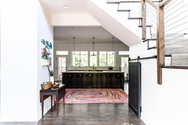 interior space featuring recessed lighting, baseboards, dark wood finished floors, and a barn door