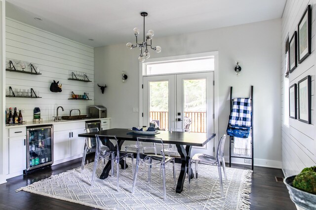 dining room with wine cooler, a chandelier, dark wood-style floors, and bar area
