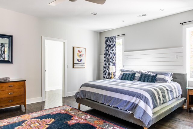 bedroom with baseboards, dark wood-style flooring, and multiple windows