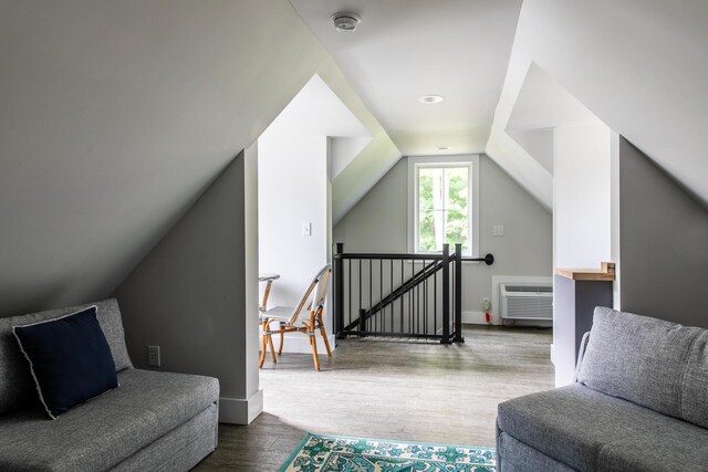 living room featuring baseboards, dark wood finished floors, a wall mounted AC, and lofted ceiling