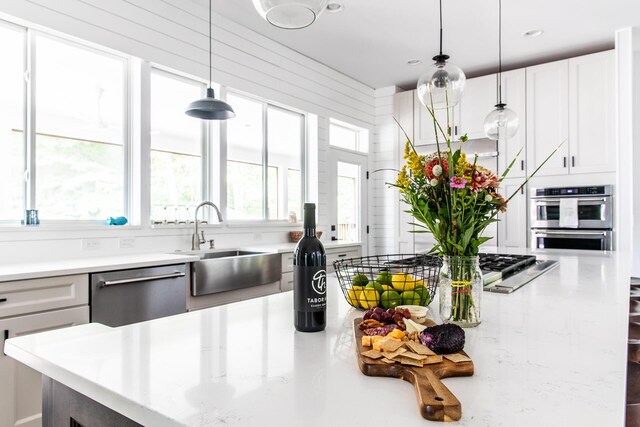 kitchen with recessed lighting, white cabinetry, a sink, hanging light fixtures, and stainless steel appliances