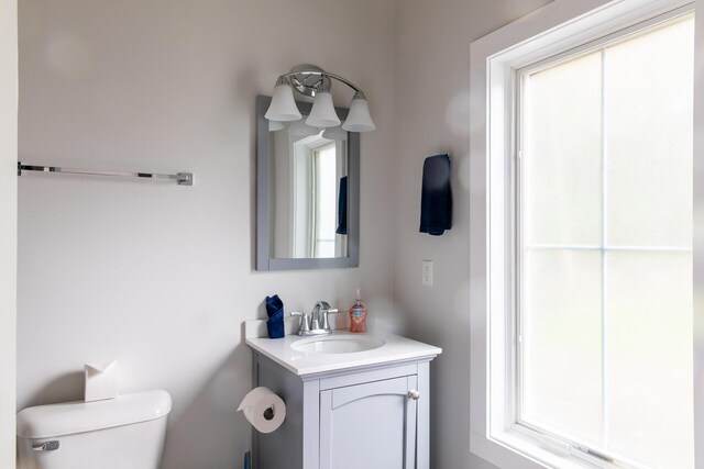 half bath featuring vanity and toilet
