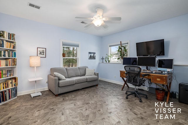 office space with a ceiling fan, baseboards, and visible vents