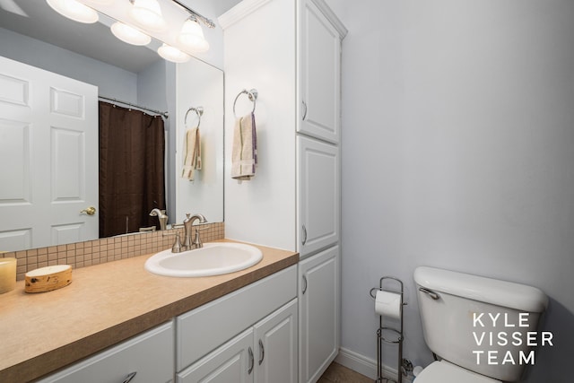 bathroom featuring vanity, baseboards, and toilet