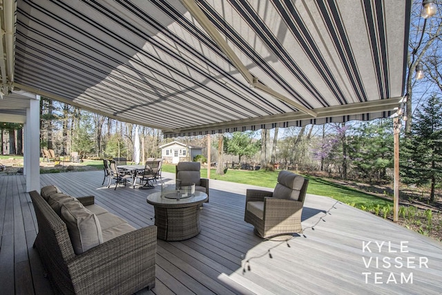 wooden deck featuring a lawn and outdoor dining space