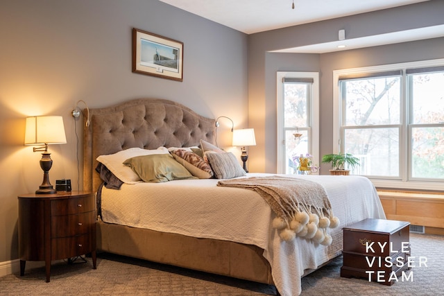 carpeted bedroom with visible vents and multiple windows