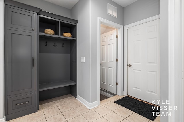 mudroom with baseboards, visible vents, and light tile patterned floors