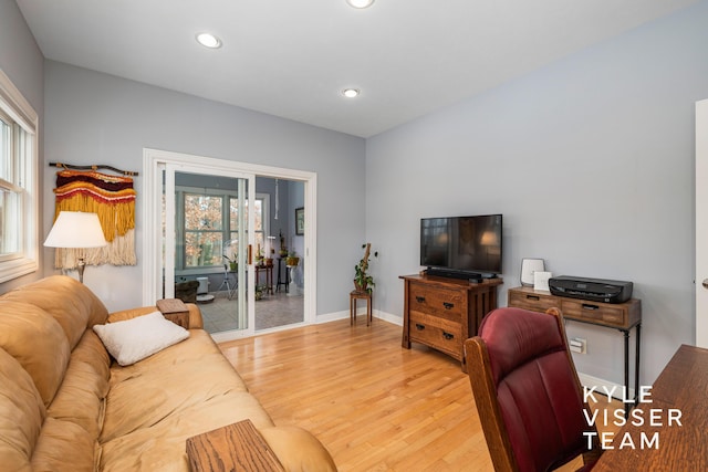 living room with recessed lighting, baseboards, and light wood-type flooring