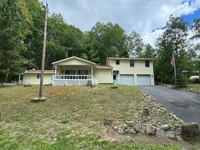 5940 Oak Rd, Rose City, MI 48654 - split level home with covered porch, a front yard, a garage, and aphalt driveway