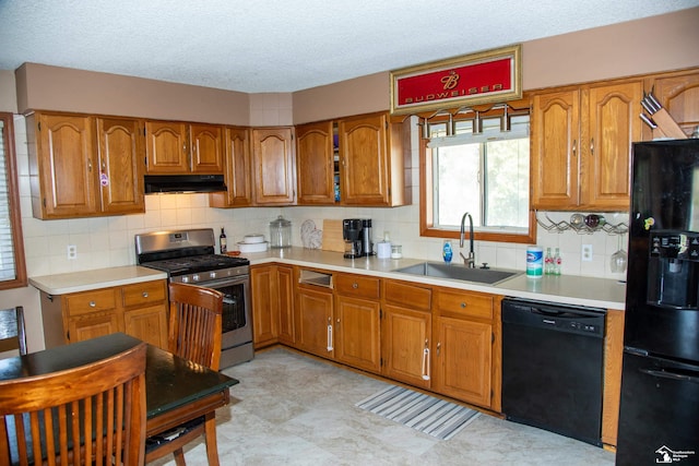 kitchen with brown cabinetry, light countertops, tasteful backsplash, a sink, and black appliances