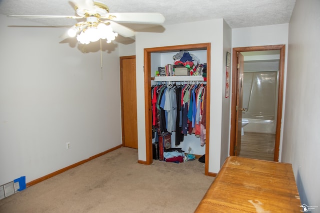 bedroom with a textured ceiling, baseboards, carpet, and a closet